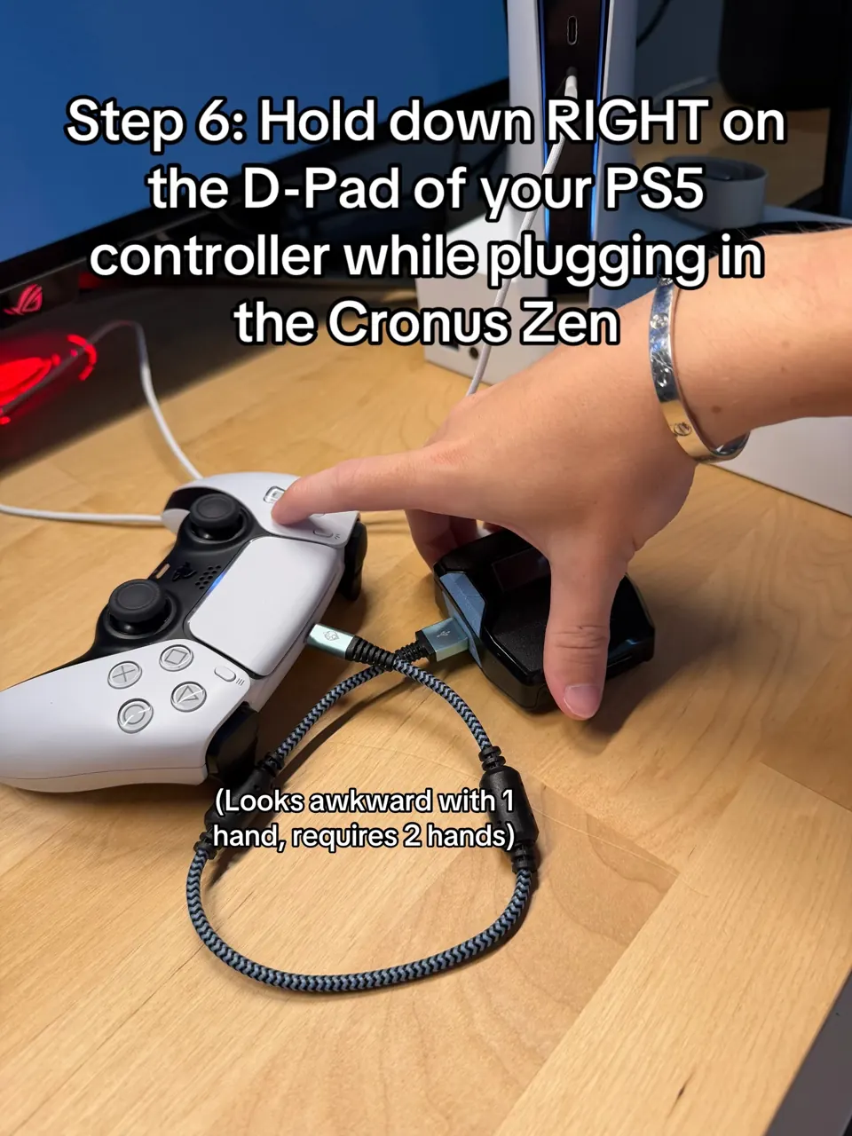 One hand holding Right on the DualSense D-pad while the other plugs the USB-C cable into the Cronus Zen